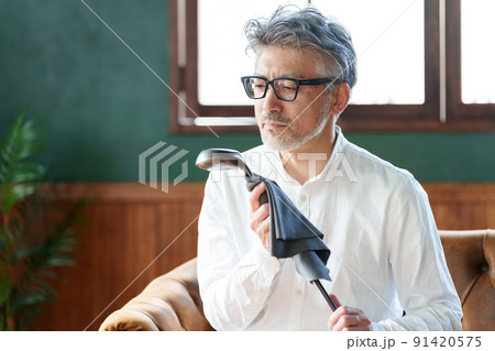 ゴルフクラブのメンテナンスをするミドル男性 91420575