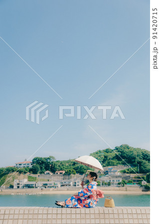 浴衣姿の女性と夏空の観光地 91420715