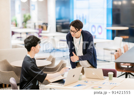 オフィスカジュアル姿で教える先輩と聞く後輩 オフィスカジュアル姿で教える先輩と聞く後輩 91421555