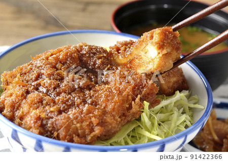 繊切りキャベツの上にたっぷりのソースが絡んだカツが乗っているソースかつ丼と味噌汁と漬物 91422366