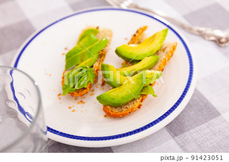 Appetizing sandwich with baguette and sliced ripe avocado 91423051