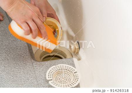 【浴室の排水口を掃除をするミドル主婦】 91426318