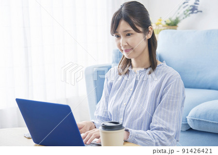 リビングでノートパソコンを使う女性 リビングでノートパソコンを使う女性 91426421