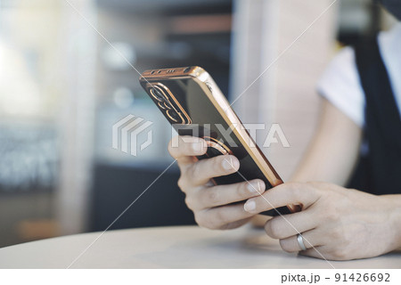 スマホを持つ女性の手元 91426692