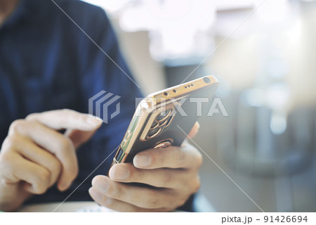 スマホを持つ男性の手元 スマホを持つ男性の手元 91426694