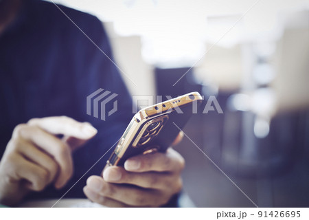 スマホを持つ男性の手元 91426695