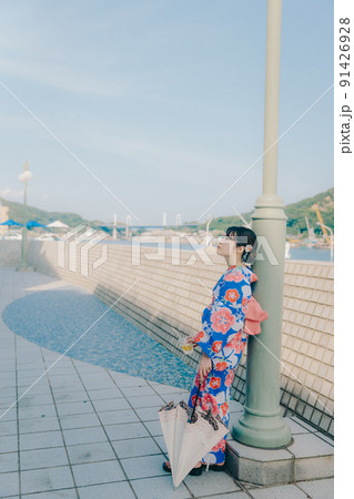 浴衣姿の女性と夏空の観光地 91426928