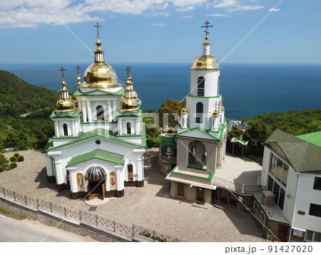 Christian church in the mountains above the sea. Temple of the Holy Archangel Michael in Oreanda. The southern coast of Crimea. Aerial view 91427020