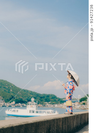 浴衣姿の女性と夏空の観光地 91427236