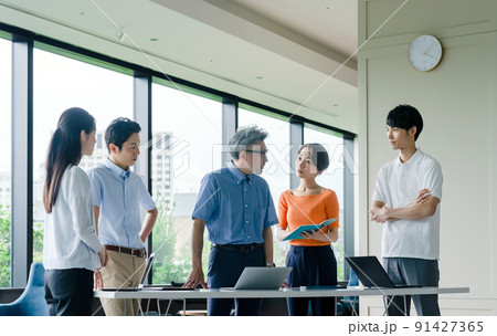 オフィスで立ってミーティングするクールビズのビジネスグループ 91427365