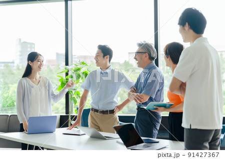 オフィスで立ってミーティングするクールビズのビジネスグループ 91427367