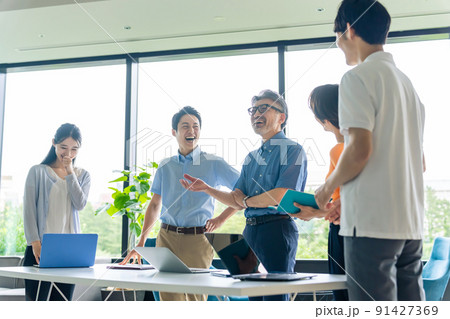 オフィスで立ってミーティングするクールビズのビジネスグループ 91427369