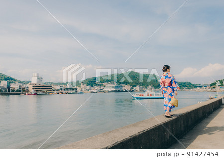 浴衣姿の女性と夏空の観光地 91427454