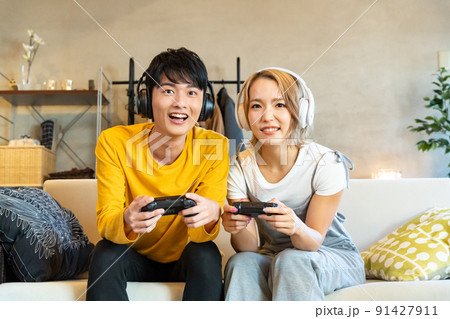 テレビゲームで遊ぶ若い男女 91427911