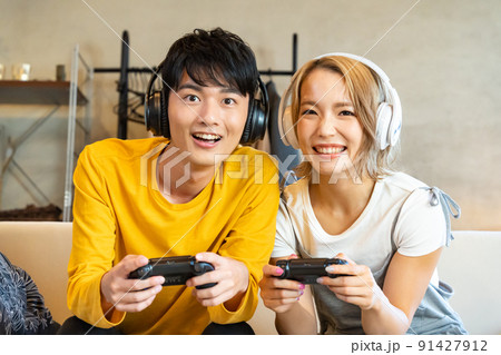 テレビゲームで遊ぶ若い男女 91427912
