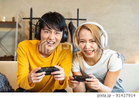 テレビゲームで遊ぶ若い男女 91427914