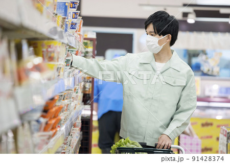 スーパーで買い物をするマスク姿の作業服男性 スーパーで買い物をするマスク姿の作業服男性 91428374