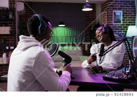Content creators having fun broadcasting live discussion on podcast station, streaming internet vlog and chatting for social media channel. Creative people talking on episode show, recording talk. Content creators having fun broadcasting live discussion on podcast station, streaming internet vlog and chatting for social media channel. Creative people talking on episode show, recording talk. 91428693