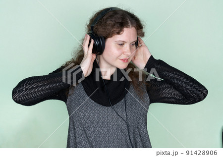 Smiling woman listening to music with headphones. Close up portrait 91428906