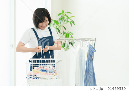 洗濯物を干す家事代行スタッフ 洗濯物を干す家事代行スタッフ 91429539