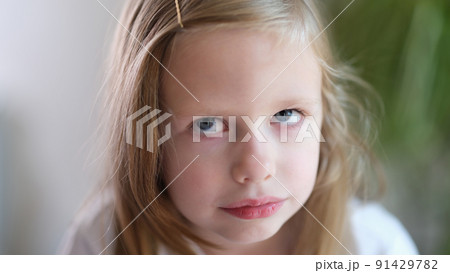 Portrait of pensive serious little child girl looks up 91429782