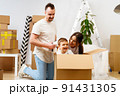 Parents and son packing boxes and moving into a new home 91431305
