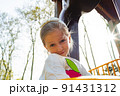 Active blonde little girl playing on a playground 91431312