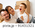 Portrait of happy family with cardboard boxes in new house at moving day 91431321