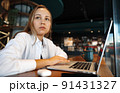 Young businesswoman sitting in a cafe and working with laptop 91431327