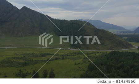 Traffic cars on road between field and mountains in Altai 91434960