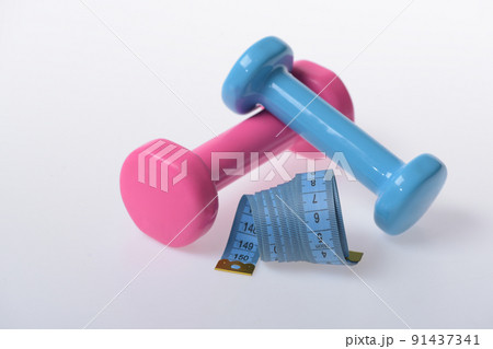 Barbells next to cyan measure tape, close up. Fitness symbols 91437341
