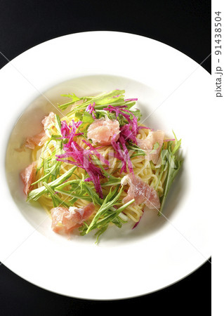 赤大根や水菜、生ハム、カッペリーニを使用した冷製パスタを黒背景で俯瞰撮影 91438504