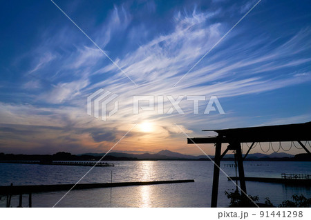 霞ヶ浦の船溜まりから望む筑波山とダイナミックな空の夕景 91441298
