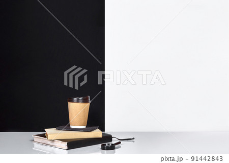 Book, notebook and cup of coffee, black and white wall. 91442843