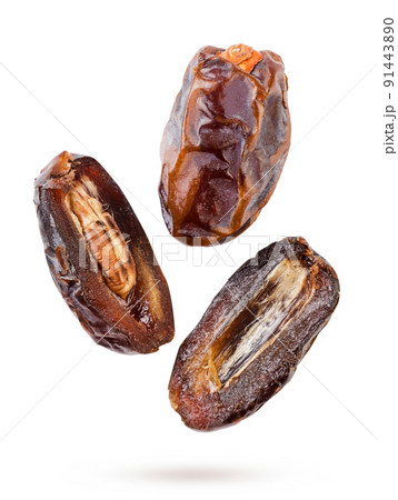 Date fruit and two halves are flying on a white background. Isolated 91443890