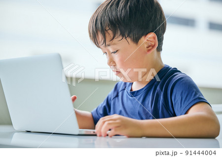 ノートパソコンでオンライン学習をする小学生の男の子 91444004