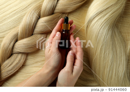 Concept of hair care with female hands hold bottle of cosmetic Concept of hair care with female hands hold bottle of cosmetic 91444060