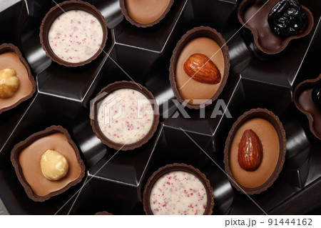 Chocolate candies in box all over background, close up 91444162
