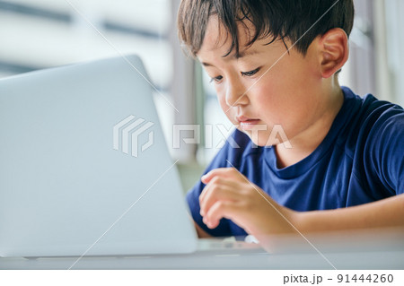 ノートパソコンでオンライン学習をする小学生の男の子 91444260