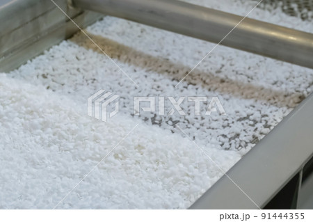 Recycled plastic granules on automatic shale shaker, conveyor belt - close up 91444355