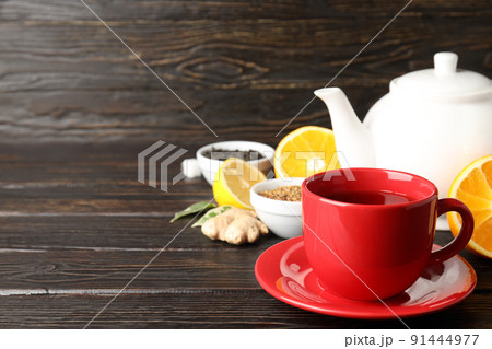 Concept of hot drink with tea on dark wooden table Concept of hot drink with tea on dark wooden table 91444977