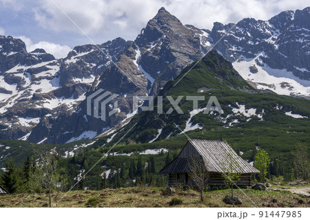Gasienicowa Valley. Tatra Mountains. An old hut in the background of the Koscielec peak. Gasienicowa Valley. Tatra Mountains. An old hut in the background of the Koscielec peak. 91447985
