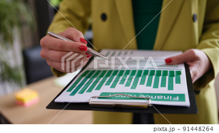 Businesswoman holds financial report and analytics in charts Businesswoman holds financial report and analytics in charts 91448264