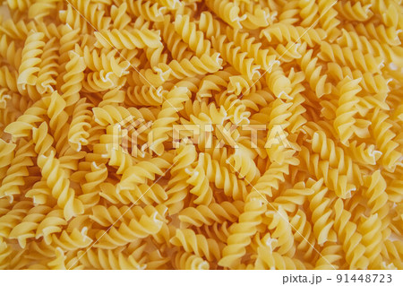 Fusilli pasta as background image. Image texture spiral macaroni. Top view. Copy, empty space for text Fusilli pasta as background image. Image texture spiral macaroni. Top view. Copy, empty space for text 91448723