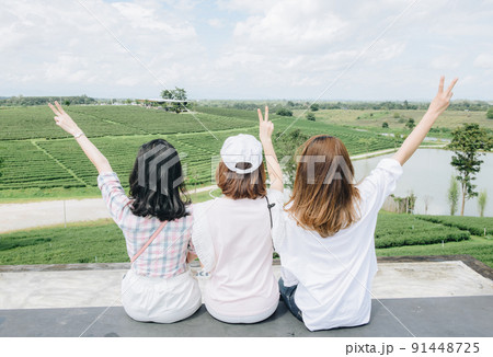 Back view of Asian tourist group taking their holiday with the beautiful view of Choui Fong tea plantation in Chiang Rai province of Thailand. Back view of Asian tourist group taking their holiday with the beautiful view of Choui Fong tea plantation in Chiang Rai province of Thailand. 91448725