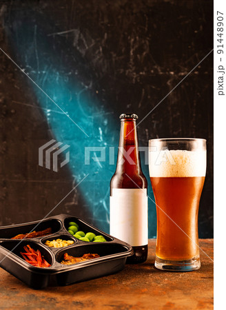 Dark craft beer in glass and bottle. Cool foamy beer and fish snack. Fish and nuts for beer. Bright beer screensaver. Dark craft beer in glass and bottle. Cool foamy beer and fish snack. Fish and nuts for beer. Bright beer screensaver. 91448907
