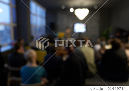 Blurred background of the business conference, one man on the stage, presentation of the project, public talk. Dark background. Copy space. Audience on the event, group of people on the training. Blurred background of the business conference, one man on the stage, presentation of the project, public talk. Dark background. Copy space. Audience on the event, group of people on the training. 91449714