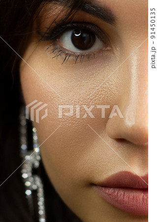 Half a beauty portrait with beautiful fashionable evening make-up, red liner on eyes and extremely long eyelashes. Pink lipstick on the lips. Cosmetology and spa facial skin care 91450135