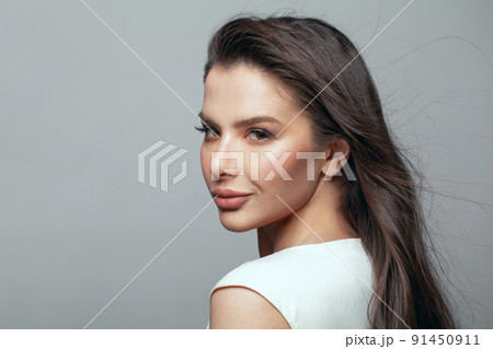 Pretty brunette woman posing in the studio on a gray background. Pretty brunette woman posing in the studio on a gray background. 91450911