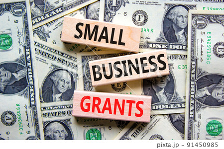 Small business grants symbol. Concept words Small business grants on wooden blocks on a beautiful background from dollar bills. Business, finacial and small business grants concept. 91450985